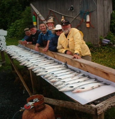 Group of guests behind a long rail of fresh salmon