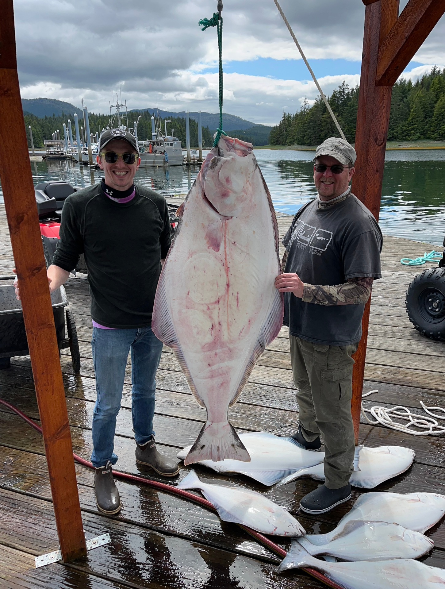 Guests posing with a giant halibut at the dock